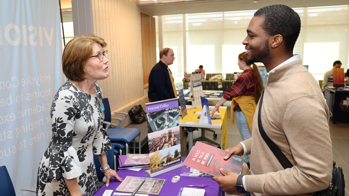 A college rep talks with an HCC student at a transfer fair